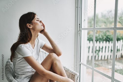 young woman sitting on the window sill