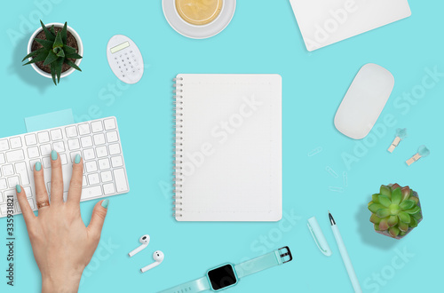 Flat layout of workplace with woman hand on keyboard