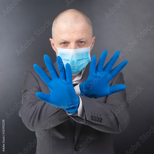 man in protective gloves shows a medical face mask. coronavirus epidemic and personal protection for humans