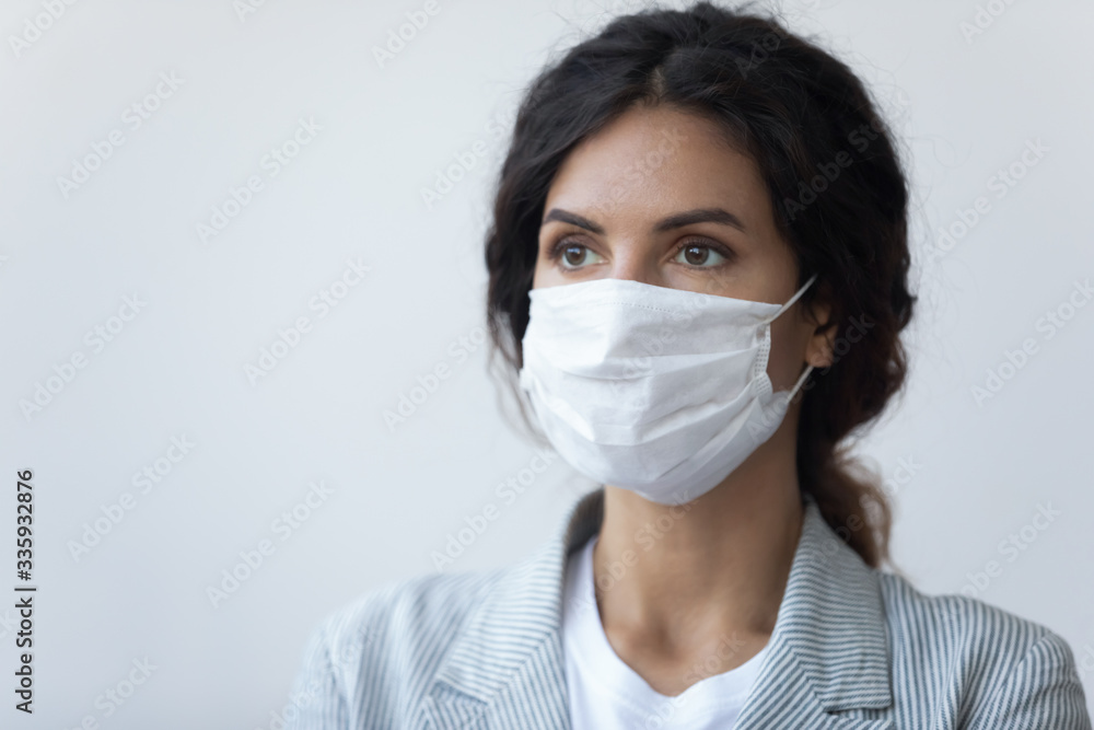 Head shot young brunette woman covering mouth and nose with special facial medical equipment, looking away. Serious lady wearing medical mask, protecting breath from air pollution or virus infection. Head shot young brunette woman covering mouth and nose with special facial medical equipment, looking away. Serious lady wearing medical mask, protecting breath from air pollution or virus infection.
