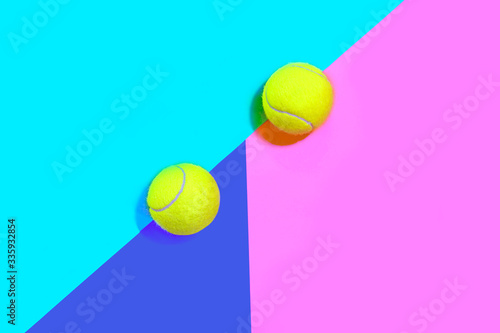 Tennis layout with tennis balls on abstract pink blue multicolored neon background with place for text. © IrynaV