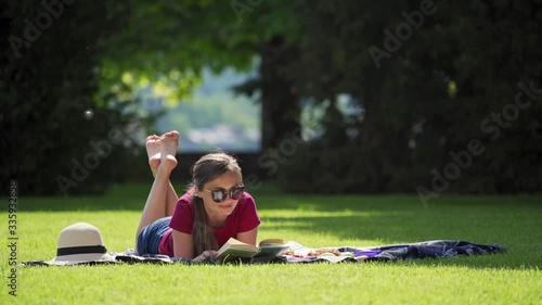 Pretty girl in sunglasses reading book in garden on sunny day, picnic, rest, sun