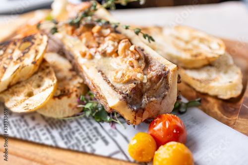 A closeup view of a dish of bone marrow, in a restaurant or kitchen setting.