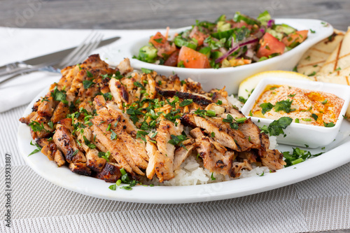 A view of a plate of chicken shawarma in a restaurant or kitchen setting.