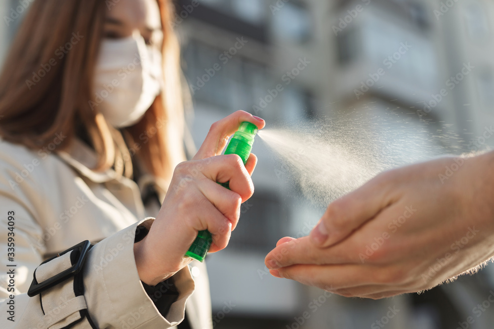 People who use alcohol-based antiseptic gel and wear a preventive mask prevent infection with the Covid-19 coronavirus outbreak, a woman washes a man's hands with hand sanitizer