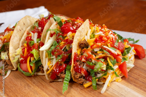 A view of several Tex-Mex tacos, or American style tacos, in a restaurant or kitchen setting.