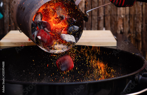 POURING BRIQUETTES ON A BARBECUE