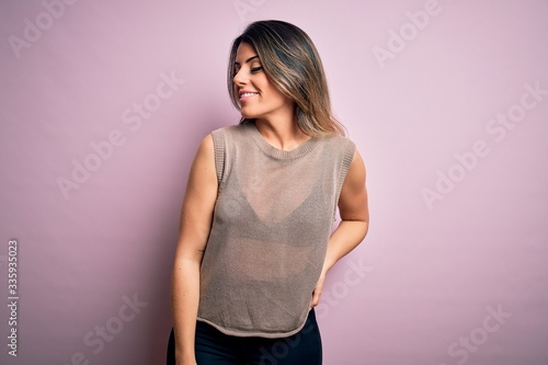 Young beautiful woman wearing fashion urban clothes, model wearing casual street style standing over pink background © Krakenimages.com