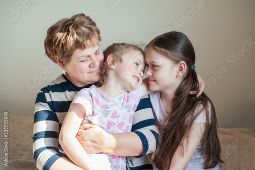 Closeup portrait of a happy grandmother and her granddaughters inside. The concept of family values.