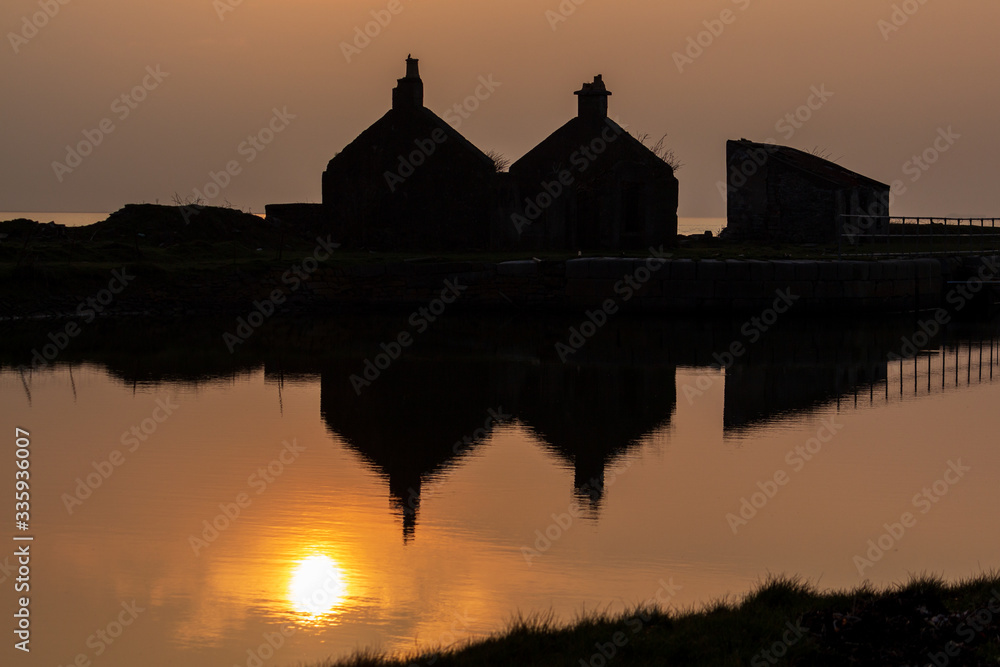 Reflections of Sunset and Silhouetted Buildings in calm water