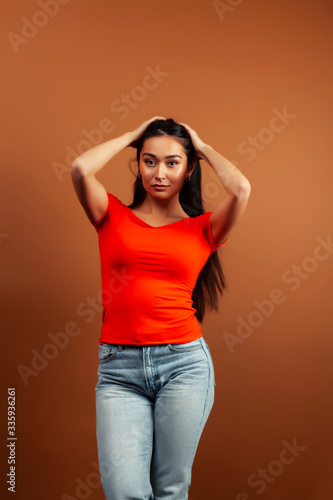 young pretty asian woman cheerful smiling posing on warm brown background, lifestyle people concept