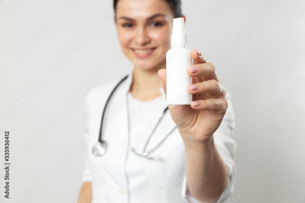 Young attractive doctor showing bottle with medicine in hand Young attractive doctor showing bottle with medicine in hand