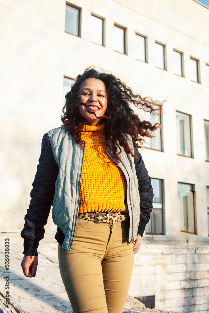 Fototapeta premium young pretty afican american girl happy smiling on city background, lifestyle people outside