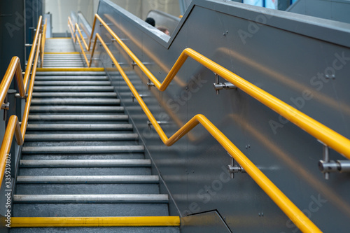 stairs with many steps and yellow railings in the subway