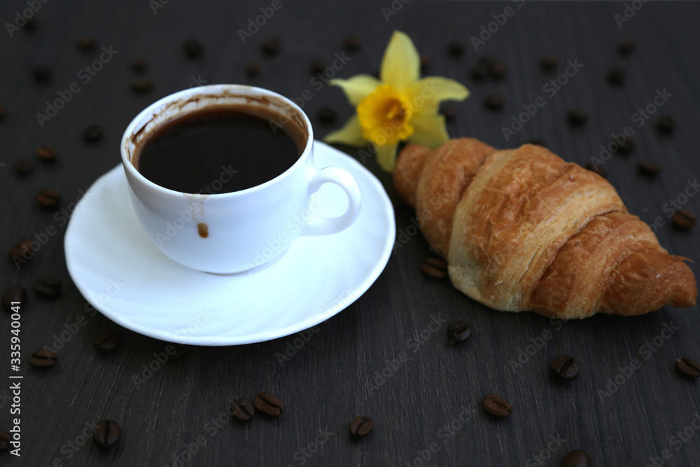 Morning coffee, spilled coffee beans, two cups of coffee, wooden table, flowers, daffodils, croissants, breakfast, dirty cup, coffee dirt Morning coffee, spilled coffee beans, two cups of coffee, wooden table, flowers, daffodils, croissants, breakfast, dirty cup, coffee dirt