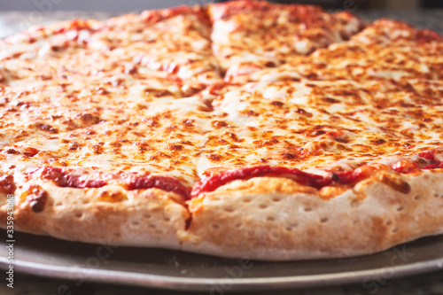 A closeup view of a plain cheese pizza on a table.