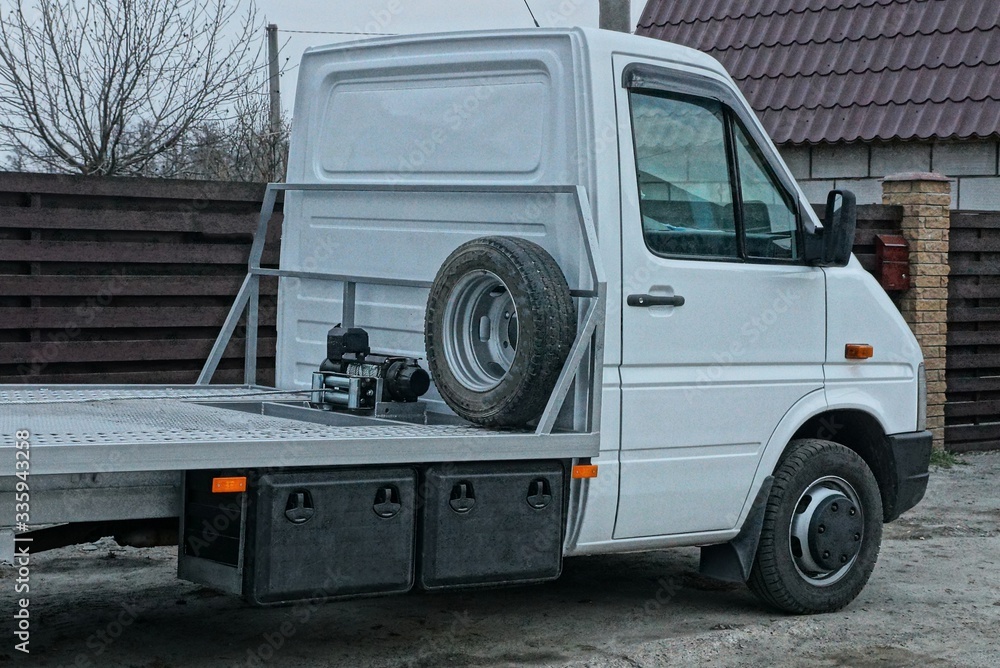 one big empty truck with a white cab is standing on a gray road in the street