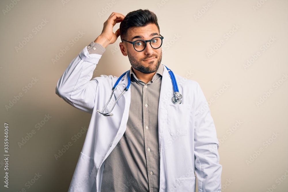 Fototapeta premium Young doctor man wearing glasses, medical white robe and stethoscope over isolated background confuse and wonder about question. Uncertain with doubt, thinking with hand on head. Pensive concept.