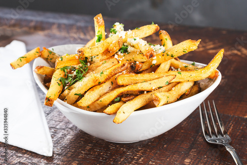 Photo A view of a bowl of rustic garlic french fries, in a restaurant or kitchen setting