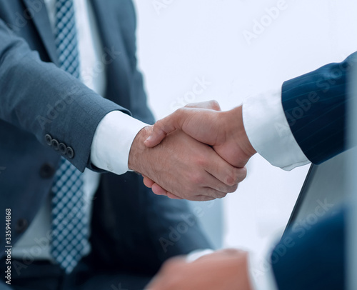 Closeup of business people shaking hands over a deal photo