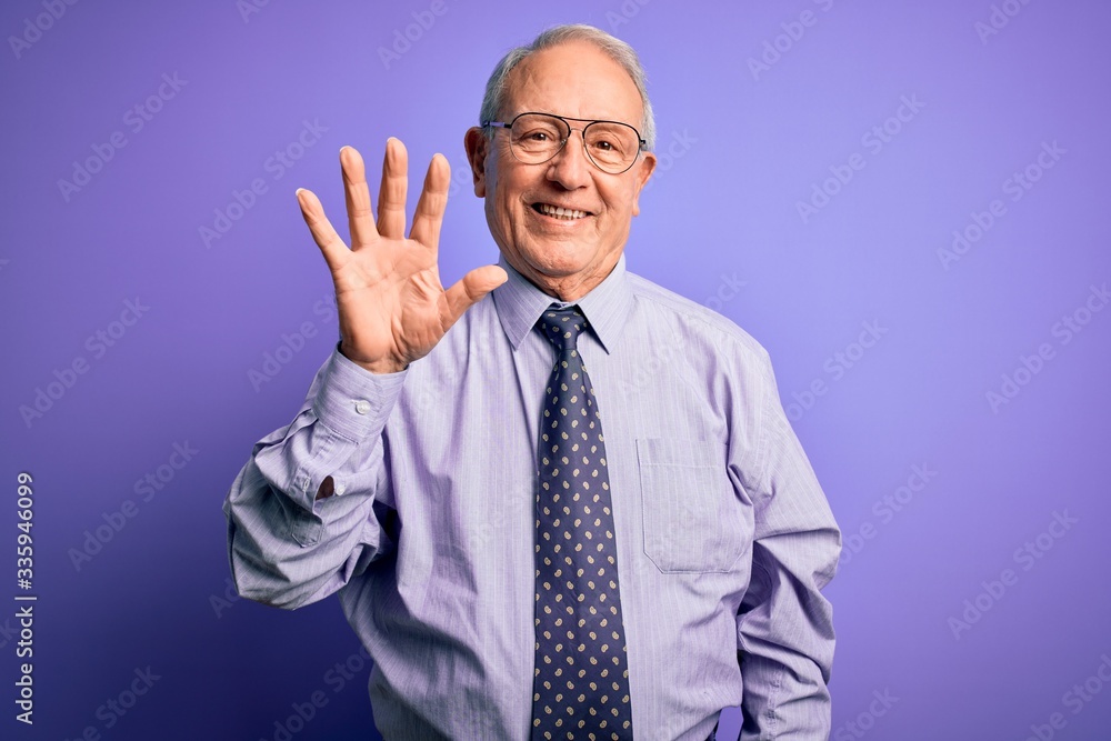 Grey haired senior business man wearing glasses standing over purple isolated background showing and pointing up with fingers number five while smiling confident and happy. Grey haired senior business man wearing glasses standing over purple isolated background showing and pointing up with fingers number five while smiling confident and happy.
