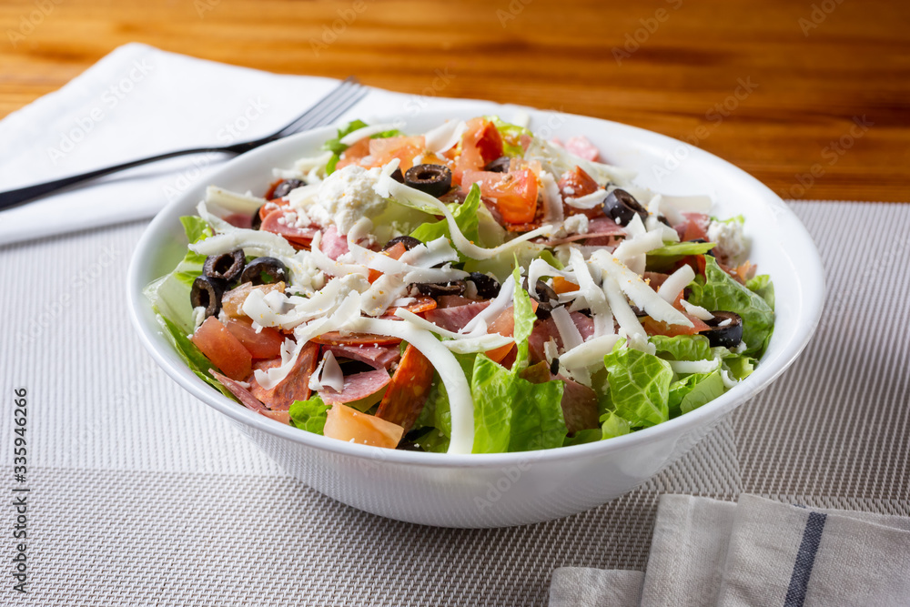 A view of a bowl of an antipasto salad, in a restaurant or kitchen setting.