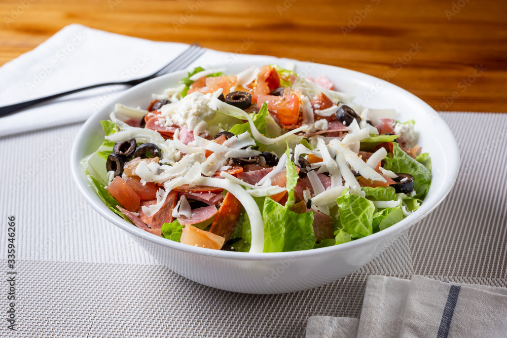 A view of a bowl of an antipasto salad, in a restaurant or kitchen setting. A view of a bowl of an antipasto salad, in a restaurant or kitchen setting.