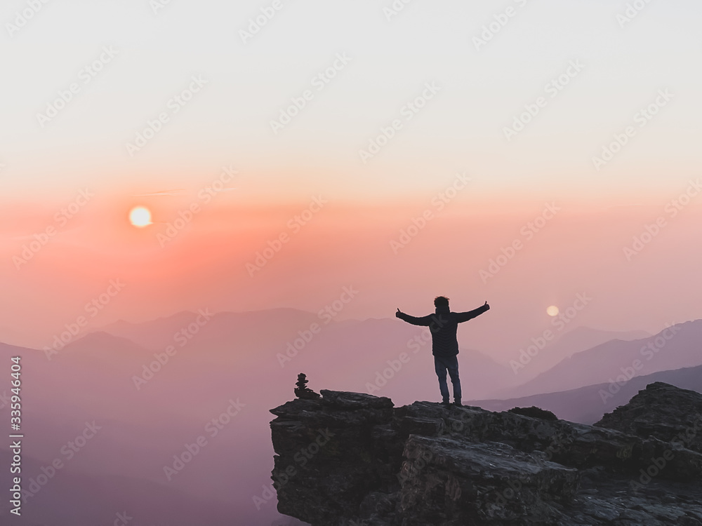 Man  taking photo on sunset mountain peak. 