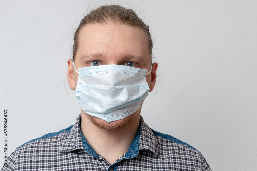 Guy puts on respiratory mask. Attractive man puts on face mask and looks at camera. Cold, flu, virus, tonsillitis, acute respiratory disease, quarantine, epidemic concept. Close-up. step by step. Guy puts on respiratory mask. Attractive man puts on face mask and looks at camera. Cold, flu, virus, tonsillitis, acute respiratory disease, quarantine, epidemic concept. Close-up. step by step.