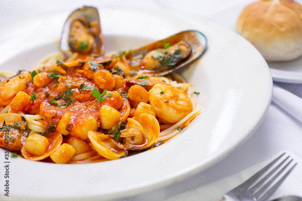A view of a bowl of seafood linguine Italian dish, in a restaurant or kitchen setting. A view of a bowl of seafood linguine Italian dish, in a restaurant or kitchen setting.