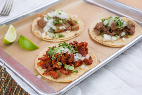 A view of a tray of street tacos, in a restaurant or kitchen setting.