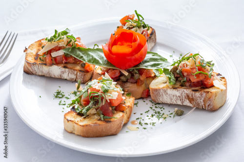 A view of a plate of bruschetta in a restaurant or kitchen setting.