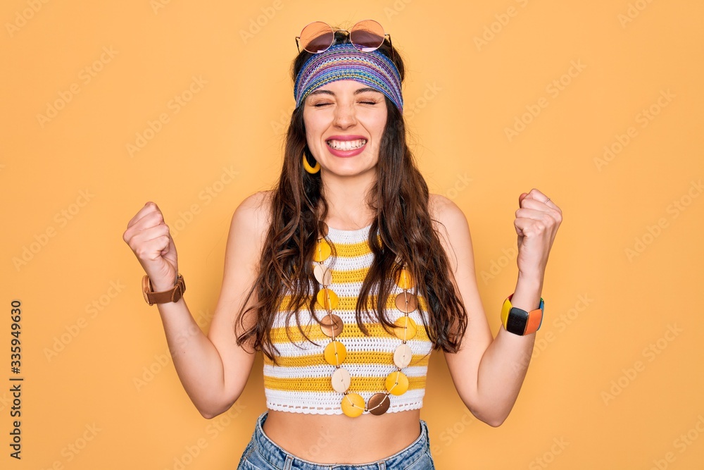 Young beautiful hippie woman with blue eyes wearing accesories and sunnglasses very happy and excited doing winner gesture with arms raised, smiling and screaming for success. Celebration concept. Young beautiful hippie woman with blue eyes wearing accesories and sunnglasses very happy and excited doing winner gesture with arms raised, smiling and screaming for success. Celebration concept.