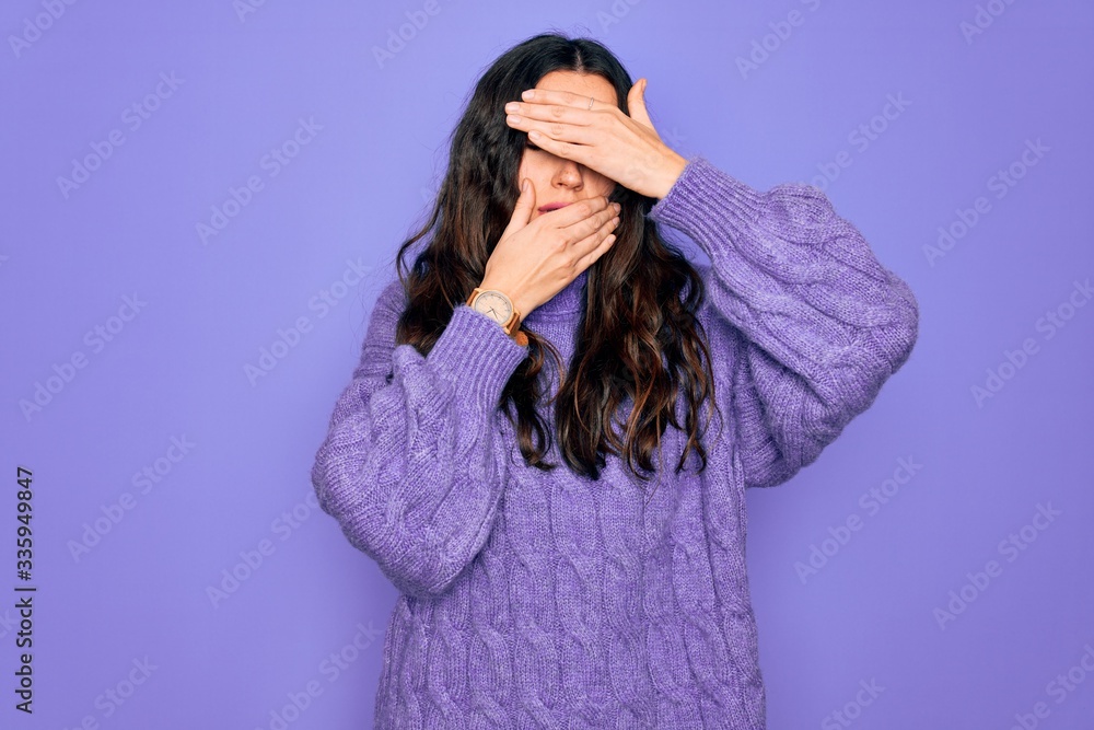 Young beautiful woman wearing casual turtleneck sweater standing over purple background Covering eyes and mouth with hands, surprised and shocked. Hiding emotion Young beautiful woman wearing casual turtleneck sweater standing over purple background Covering eyes and mouth with hands, surprised and shocked. Hiding emotion