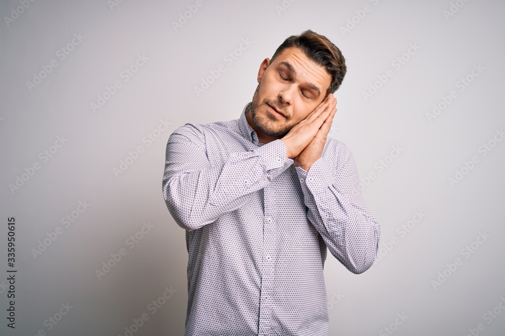 Young business man with blue eyes standing over isolated background sleeping tired dreaming and posing with hands together while smiling with closed eyes. Young business man with blue eyes standing over isolated background sleeping tired dreaming and posing with hands together while smiling with closed eyes.