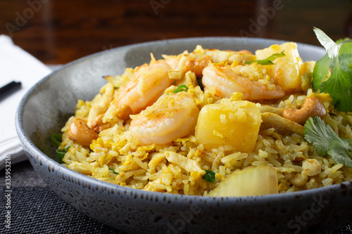 A view of a bowl of shrimp fried rice, in a restaurant or kitchen setting,