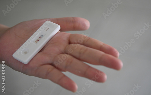 Close up pregnancy test in female hand on with positive pregnant on blurred background.