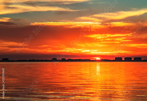 Indian Beach 6, Sarasota, Florida, beautiful red orange sunset, visible sun, water buildings, skyline, sun-stream , reflection
