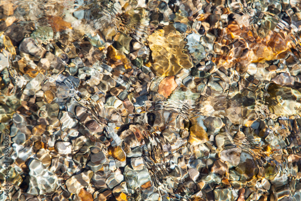 Beautiful stones on the bottom of a clean river, natural background Beautiful stones on the bottom of a clean river, natural background