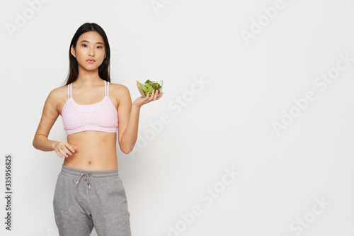 young woman holding a bowl of healthy food © SHOTPRIME STUDIO