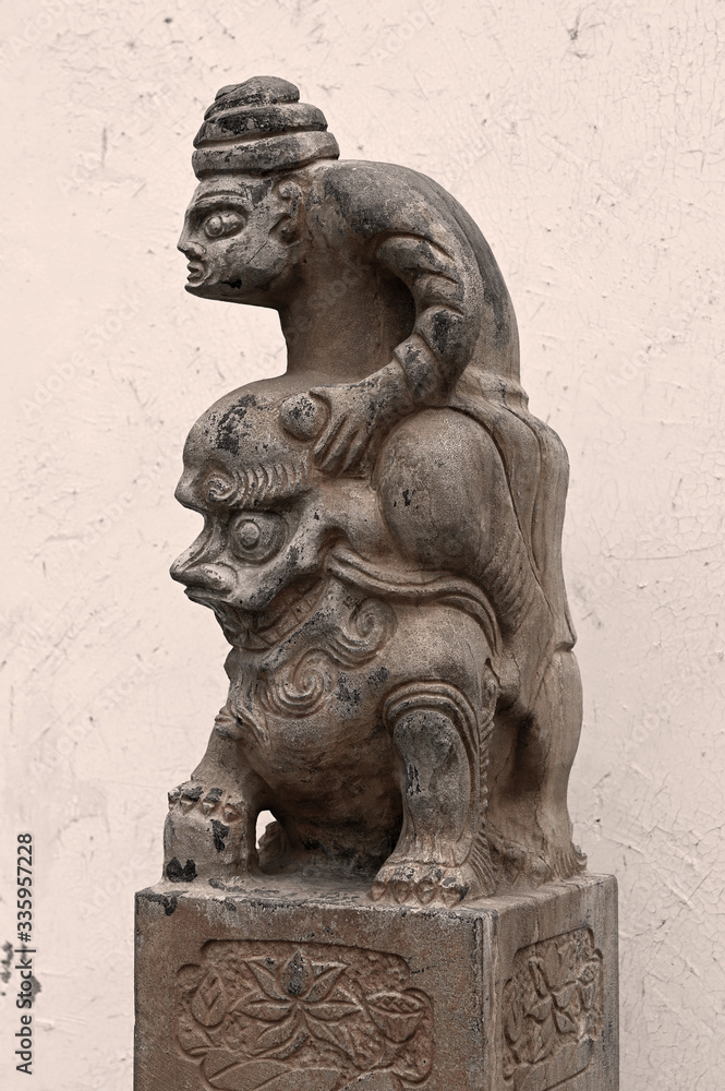 Stone pillar sculpture of ancient Chinese figures riding Lions