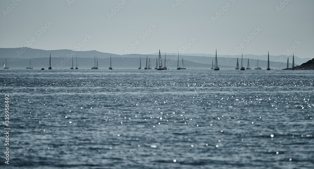 Beautiful sea landscape with sailboats, the race of sailboats on the horizon, a regatta, a Intense competition, bright colors, island with windmills are on background