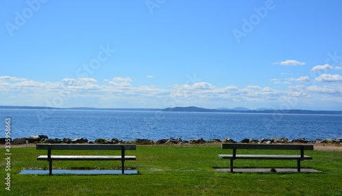 Two benches on a walking path overlooking the Pacific Ocean in Seattle, WA