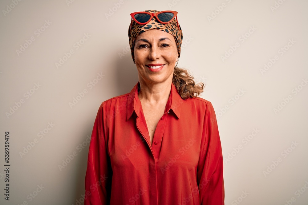 Middle age brunette woman wearing handkerchief on head and shirt over white background with a happy and cool smile on face. Lucky person. Middle age brunette woman wearing handkerchief on head and shirt over white background with a happy and cool smile on face. Lucky person.