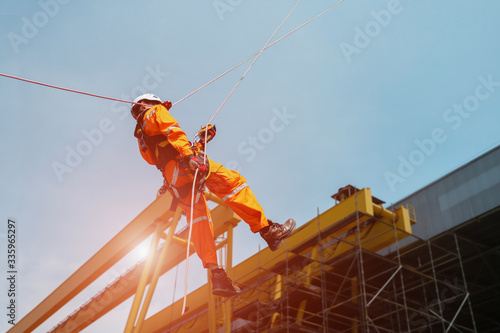 Tableau sur toile Worker Demonstration or rope access the Abseiling of high place wearing equipmen