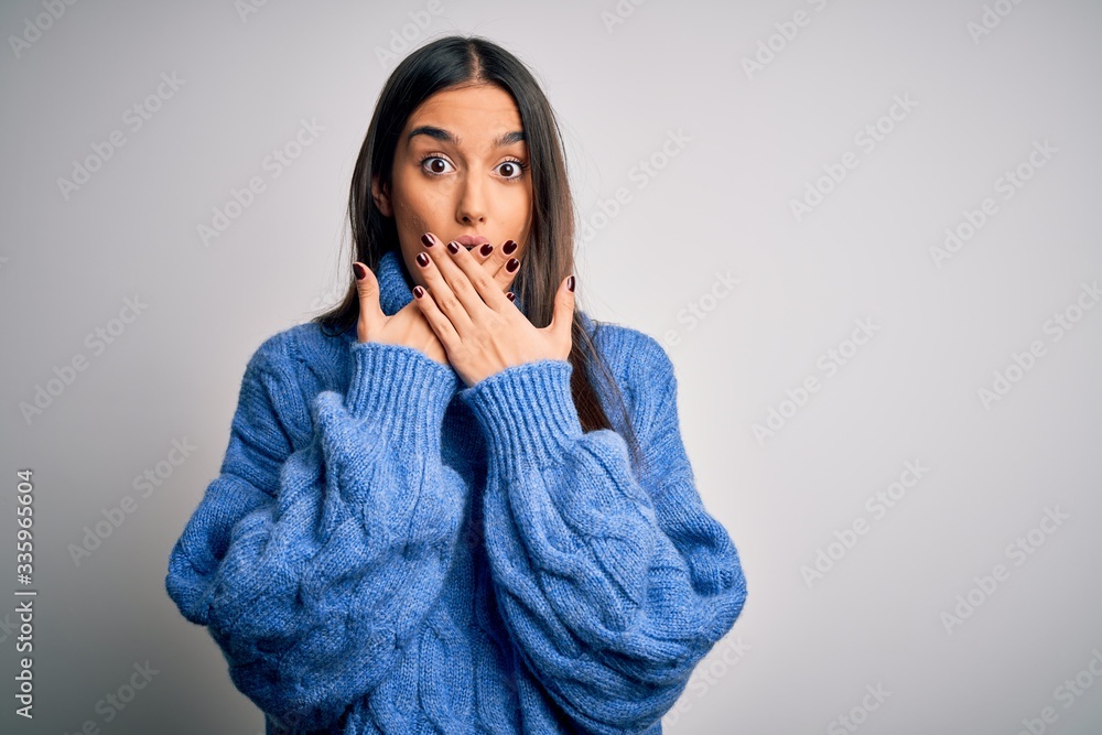 Young beautiful brunette woman wearing casual turtleneck sweater over white background shocked covering mouth with hands for mistake. Secret concept. Young beautiful brunette woman wearing casual turtleneck sweater over white background shocked covering mouth with hands for mistake. Secret concept.