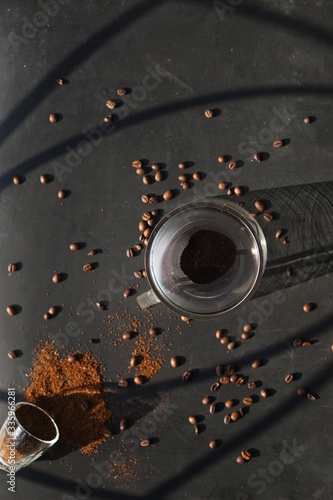 an overhead shot of scattered beans with drip form of coffee