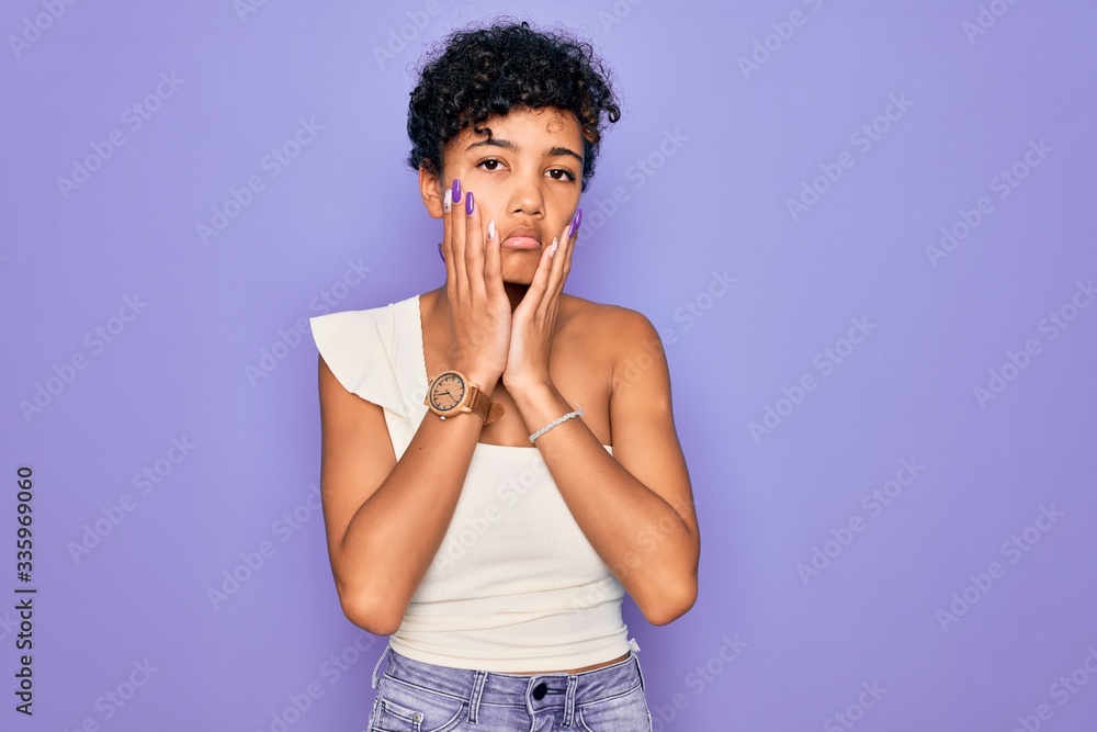 Young beautiful african american afro woman wearing casual t-shirt over purple background Tired hands covering face, depression and sadness, upset and irritated for problem Young beautiful african american afro woman wearing casual t-shirt over purple background Tired hands covering face, depression and sadness, upset and irritated for problem