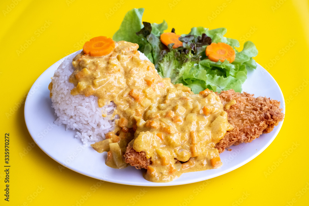 Curry fried Batter Fish with rice on plate over yellow background. Top view, flat lay. Curry fried Batter Fish with rice on plate over yellow background. Top view, flat lay.