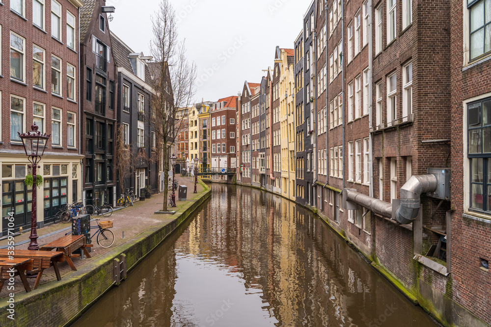 Typical famous water canal and dancing houses in empty Amsterdam downtown without people due to Coronavirus Covid-19, Netherlands.